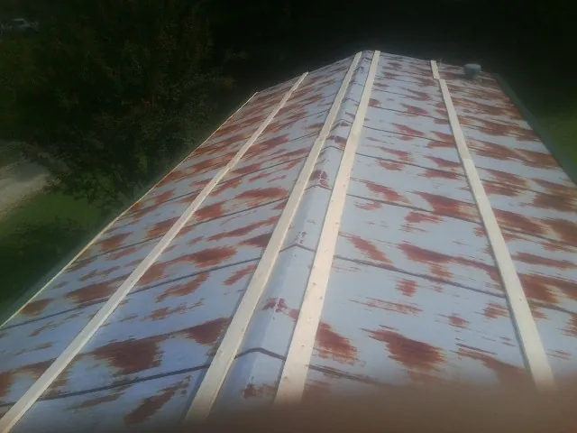 Rusted metal roof panels with new wood purlins before replacement — Storm Damage Roof Repair in Finley by Roofing Brothers