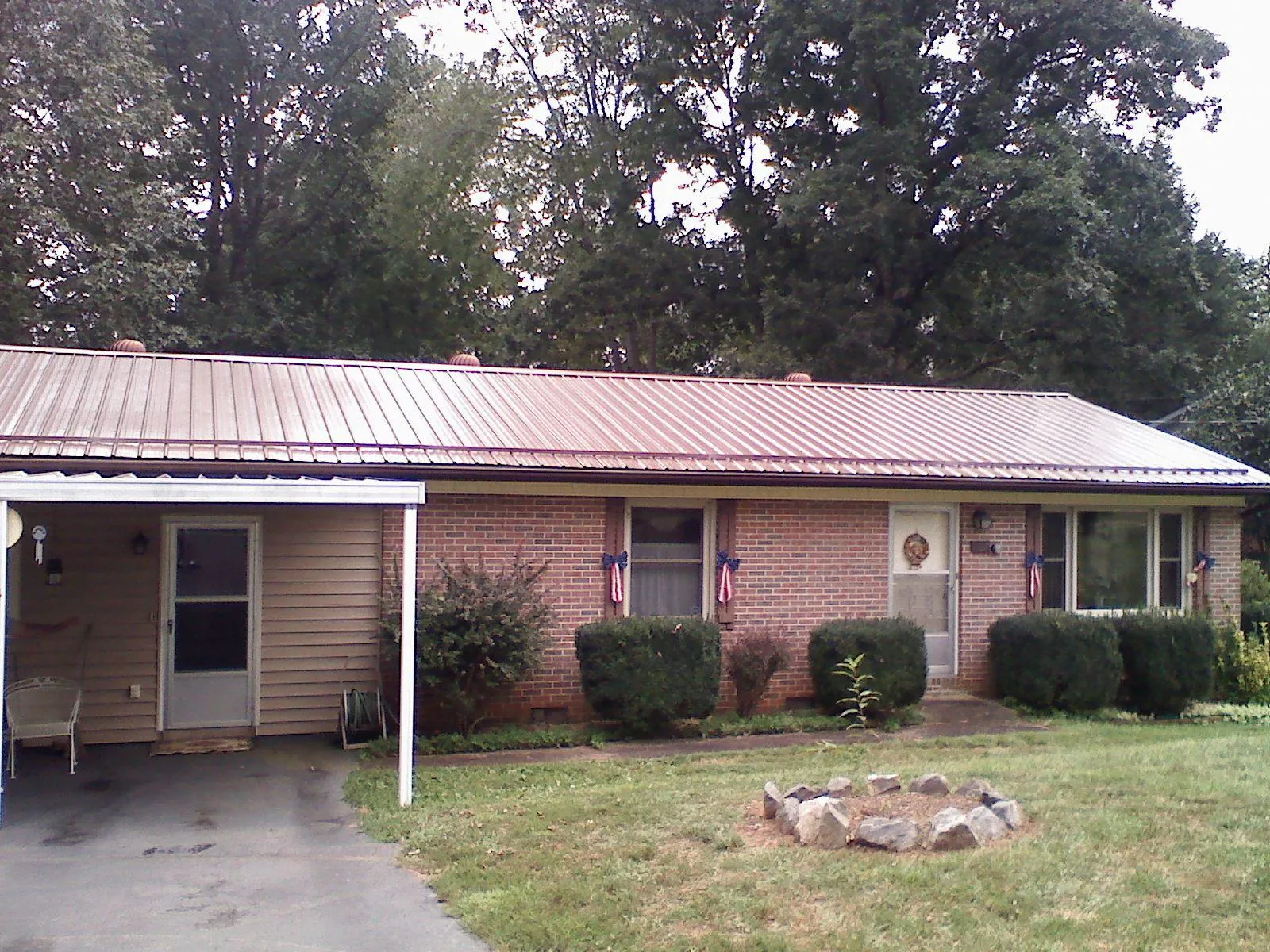Bronze metal roof and carport on a brick ranch home — Roof Repair work by our crew in Finley
